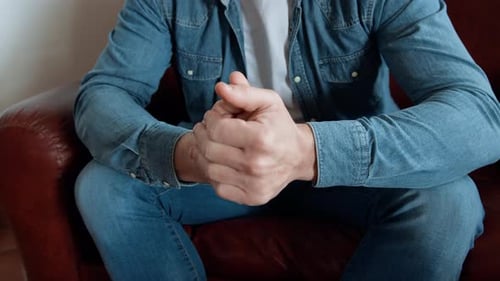 Man Relaxing On The Sofa Touching Hands