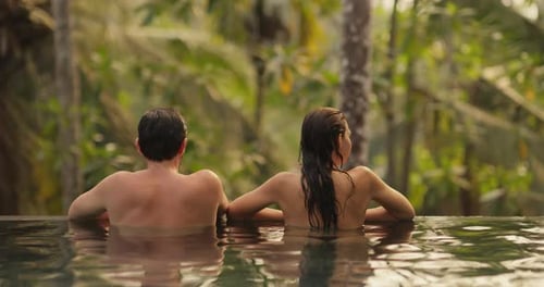 Couple Together Relaxation and Spending Time in Infinity Swimming Pool Outdoors During Tropical