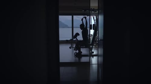 The Silhouette of Fitness Captured Beautifully in a Modern Home Gym During the Dusky Hours