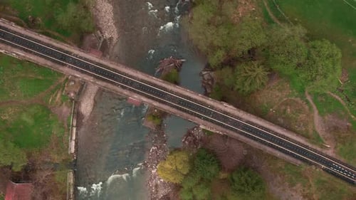 Viaduct railroad bridge through river in mountains. Vertical video