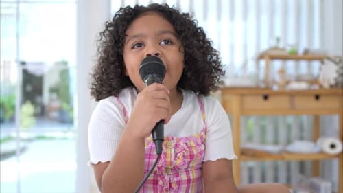 Girl Singing Into Microphone in Bright Room