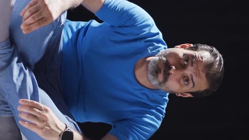 Vertical video of Psychologically troubled man looking strangely at camera.