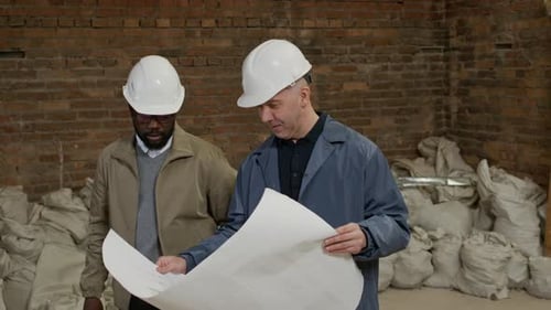 Construction Workers Reviewing Blueprints on Building Site
