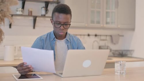 Young Man Using Laptop in Home Kitchen