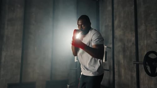 Man Boxing Training Punches in Gym African American Sportive Focused Boxer Fighter Practicing Hits