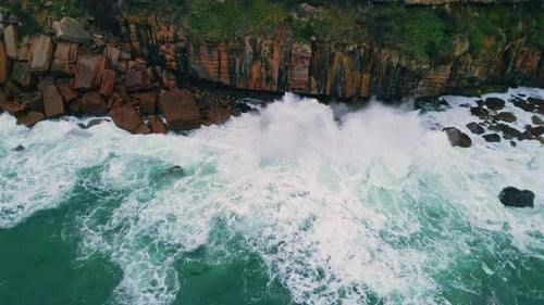 Dramatic Aerial Ocean Crashing of Dark Coastal Rocks