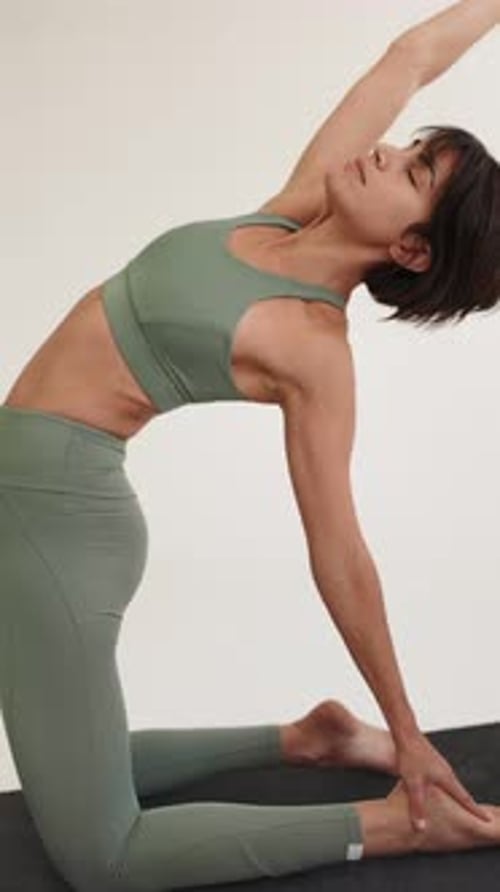 Woman Stretching in Kneeling Yoga Pose Indoors