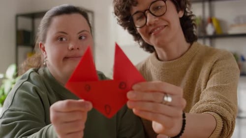 Two Friends Holding Red Origami Craft