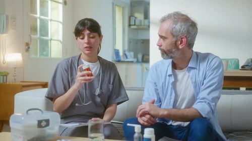 Friendly Doctor Explaining Medication to Patient at Home