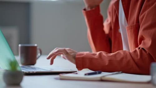 Office Worker Using Touchpad at Laptop Calling Smartphone on Workspace Closeup