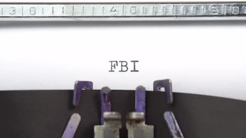 FBI word closeup being typing and centered on a sheet of paper on old vintage typewriter