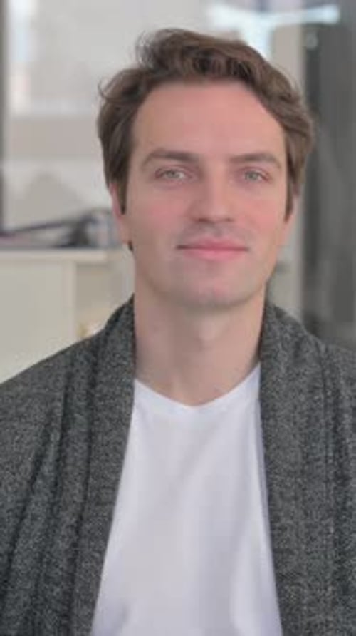 Smiling Man Gives a Thumbs Up Gesture Indoors