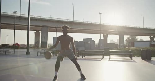 Young Man Playing Basketball Outdoors
