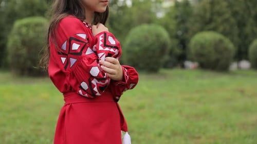 Girl Smiling in Embroidered Red Dress in Field