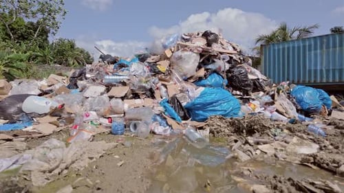 Blick vom Erdgeschoss auf eine Müllhalde an einem sonnigen Tag mit schmutzigem Wasser und verschwendetem Plastik