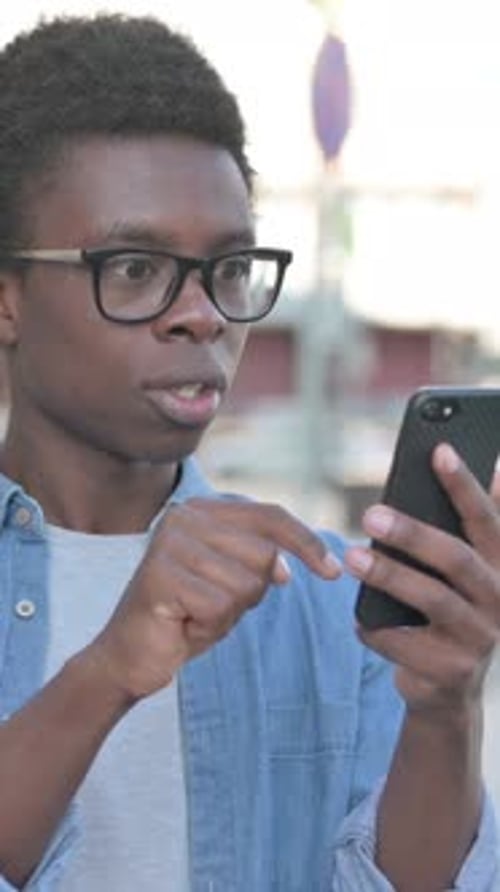 Happy Man Reacting to Good News on Phone Outside