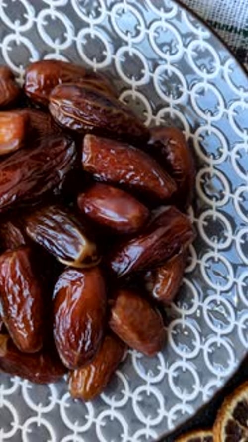 Dried dates on a ceramic plate for Ramadan or Iftar. Dates fruit as a background