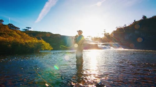 Fisherman Casts the Line on a River at Sunrise