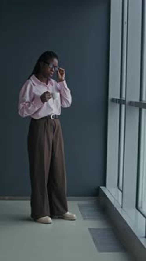 Woman with Warm Drink in a Modern Office