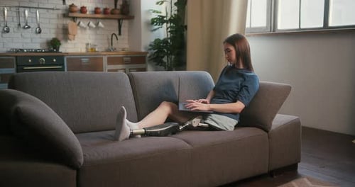 Woman With Prosthetic Limb Works on Laptop at Home