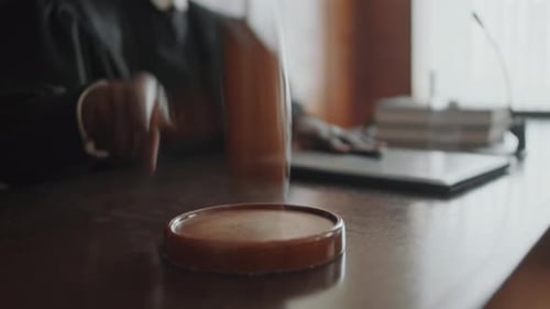 La mano de un juez irreconocible golpea un bloque de sonido con un mazo de madera