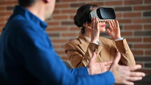 Woman using a Virtual Reality headset in an office while explains and gesticulates