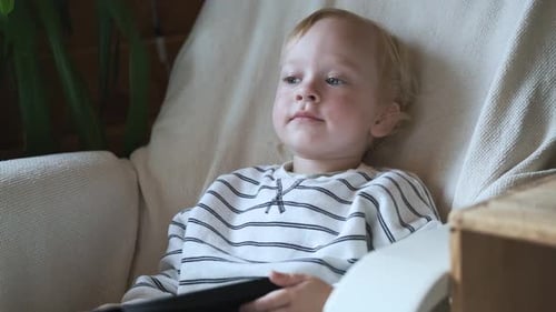 Young Child Engrossed in Tablet at Home