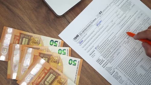 US Tax Form Filled on Desk with Currency