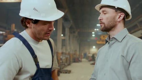 Technician and Engineer Shaking Hands, Discussing Papers at Work in Factory