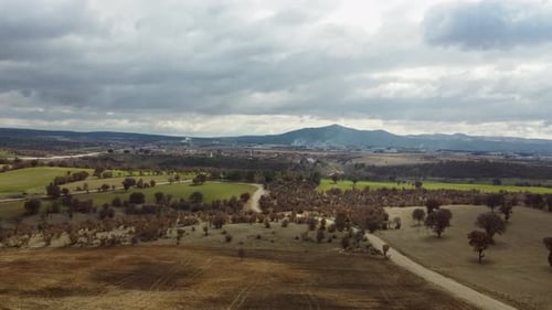 Aerial view of trees, vast land and mountains in cloudy weather 4K