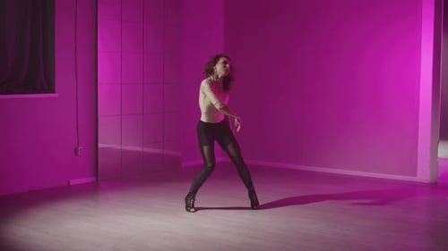 Stylish Woman Dancing in a Pink Lit Studio