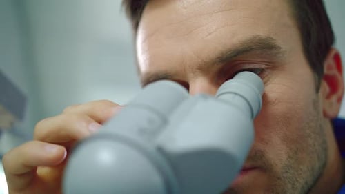 Male scientist concentrated on microscope research in the laboratory