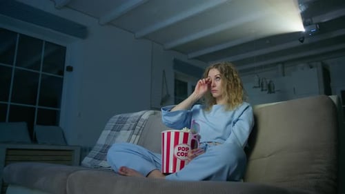 Woman Watching Movie on Projector with Popcorn
