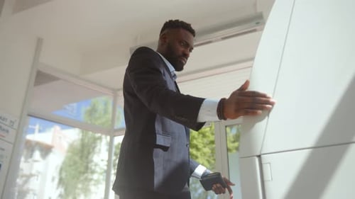 Irritierter Bankkunde, der ein Problem mit der ATM-Kreditkarte hatte, blieb in der Seite des Geldautomaten stecken