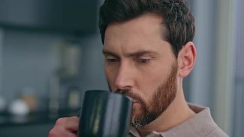 Man Drinking Coffee While Using Cell Phone
