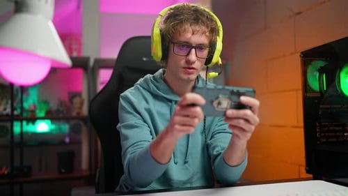Young Adult Gamer Playing on Smartphone Indoors