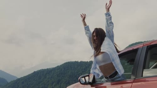 Woman Leans Out Car Window on Mountain Road
