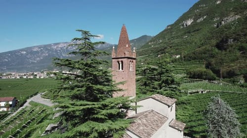 Aerial video above a small church near vineyards in the northern Dolomites