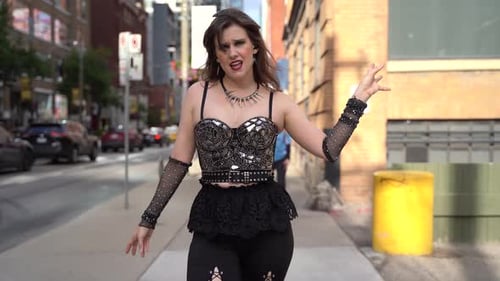 Young woman walking singing on the street in the city center 4K