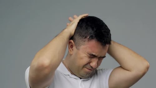 Man Experiencing Headache and Discomfort, Hands on Head