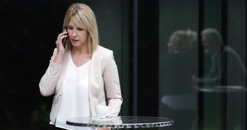 Female business executive using a smartphone in a cafe outdoors