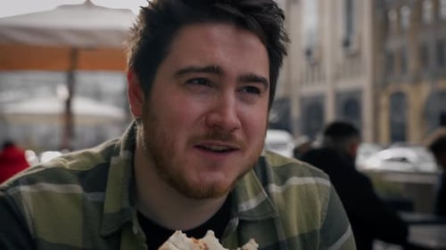 A man on a date with a woman eats pizza and tells jokes