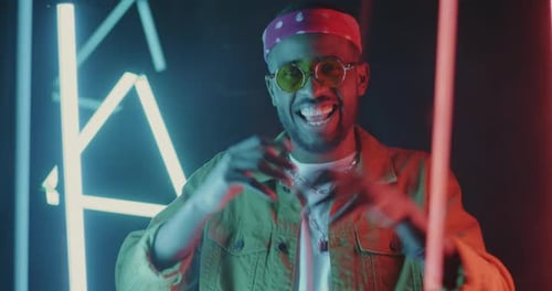 Slow Motion Portrait of Joyful African American Dancer Chilling in Night Club with Neon Illumination