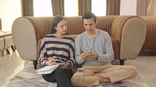 Indian couple counting money and calculating budget