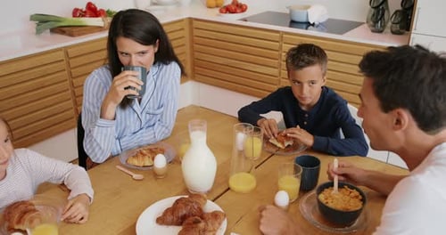 Family enjoying breakfast together at kitchen table