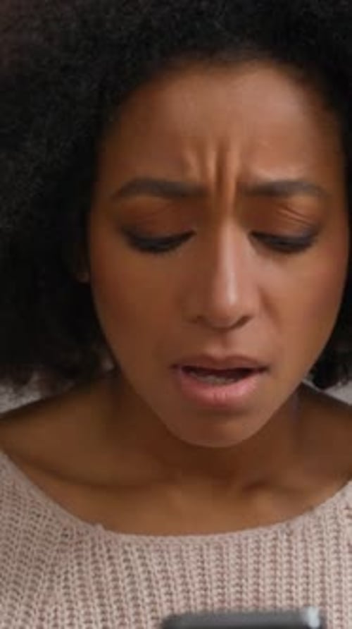 Upset Woman Looking at Phone With Frustrated Expression