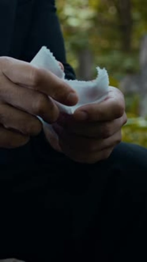Hands of Stressed Man Clutching Handkerchief in Cemetery
