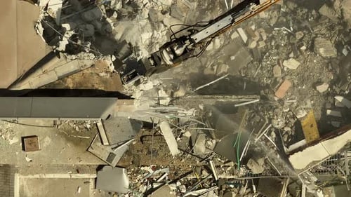 Building demolition excavator using Pulverizer Jaws to demolish a residential building