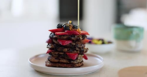 Pfannkuchenstapel, Honig und Obst zum Frühstück und Essen in der Küche mit Kreativität und Ernährung
