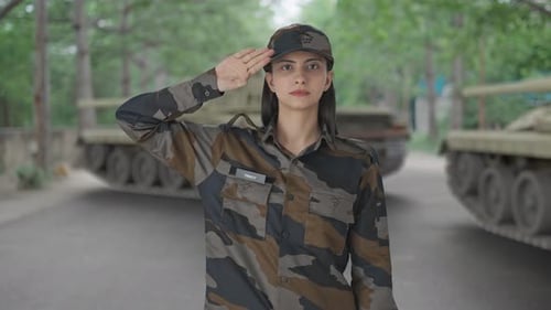 Woman in Military Uniform Saluting by Tanks